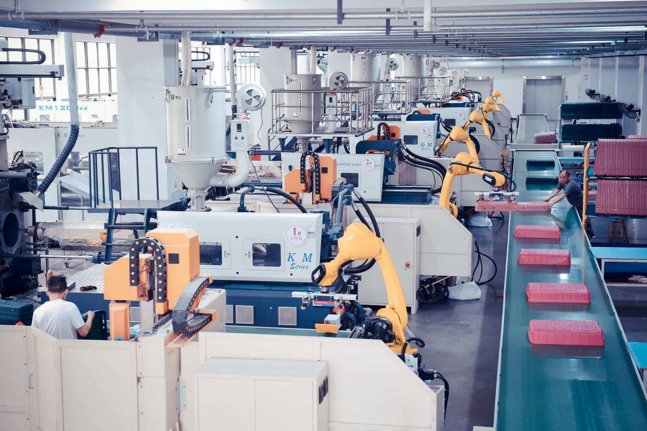 Injection molding workshop with robotic arms on a representative production programme