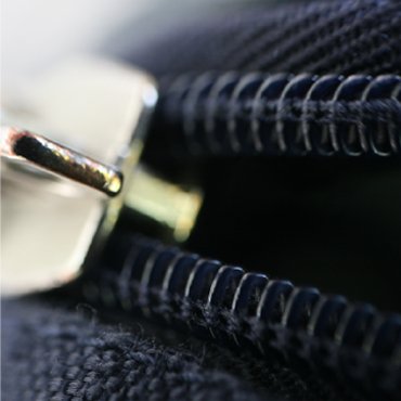 Close-up of a luggage zipper and slider assembly